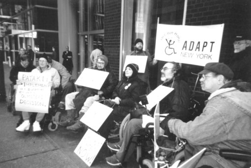 ADAPT members block the entrance to Gov. Pataki's city offices - see caption for complete description