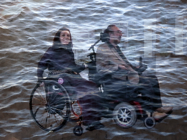 Danny in powerchair pulling Nadina in manual chair, under water